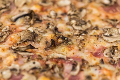 Fresh made Pizza full screen macro shot for use as background image or as texture