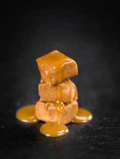 Caramel Sauce on a vintage background as detailed close-up shot (selective focus)