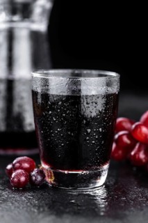 Portion of healthy Red Grape Juice on a slate slab (selective focus)