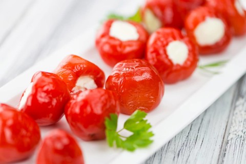 Fresh made Red Pepper (stuffed with cheese) on an old and rustic wooden table (selective focus,