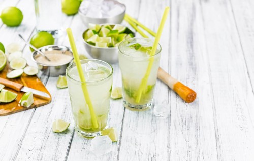 Fresh made Caipirinha with ingredients in the background