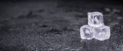 Some melting Ice cubes on a vintage slate slab (selective focus)