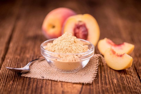 Ground Peaches as high detailed close-up shot on a vintage wooden table, selective focus