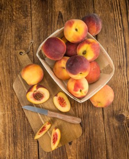 Peaches on an old wooden table as detailed close-up shot, selective focus