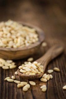 Pine Nuts on an old wooden table as detailed close-up shot (selective focus)