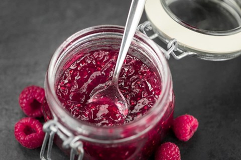 Fresh made Raspberry Jam on a vintage background as detailed close-up shot