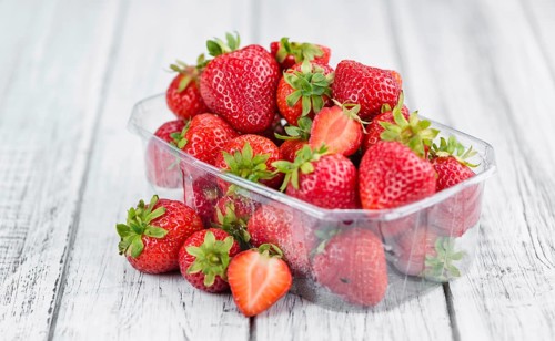 Strawberries as high detailed close-up shot on a vintage wooden table, selective focus