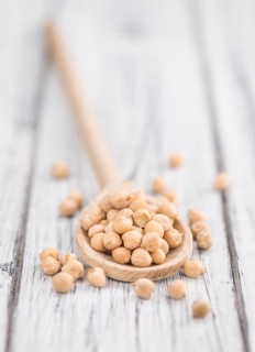 Dried Chickpeas as high detailed close-up shot on a vintage wooden table, selective focus
