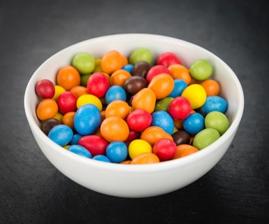 Portion of Cocolate coated Peanuts as detailed close up shot on a slate slab (selective focus)