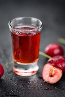 Homemade Cherry Liqueur on vintage background selective focus, close-up shot
