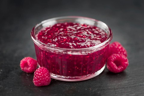 Some Raspberry Jam on a slate slab as detailed close-up shot, selective focus