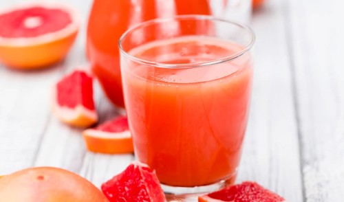 Portion of freshly squeezed Grapefruit Juice on a vintage background (selective focus, close-up