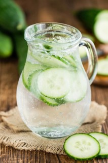 Cucumber Water on rustic wooden background as close-up shot