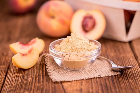Peach powder on an old wooden table as detailed close-up shot, selective focus