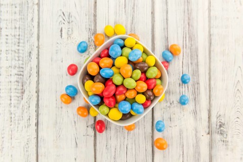 Fresh made Cocolate coated Peanuts on a vintage background (close-up shot)