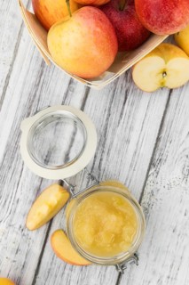 Portion of fresh made Applesauce (selective focus) on a wooden table