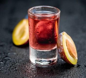 Fresh made Plum Liqueur on a vintage background as detailed close-up shot