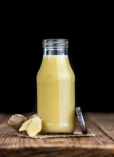 Healthy Ginger Sap on a wooden table as detailed close-up shot (selective focus)
