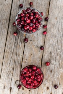 Vintage wooden table with Cranberries (preserved) (selective focus, close-up shot)