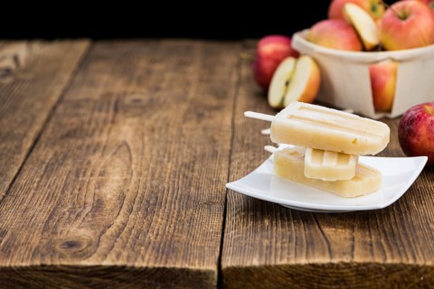 Portion of homemade Apple Popsicles (selective focus, close-up shot) on a vintage background