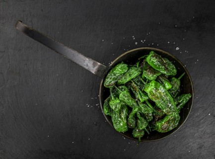 Portion of Pimientos de Padron on a rustic slate slab, selective focus, close-up shot