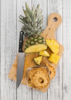 Pineapple rings (dried) on rustic wooden background as close-up shot