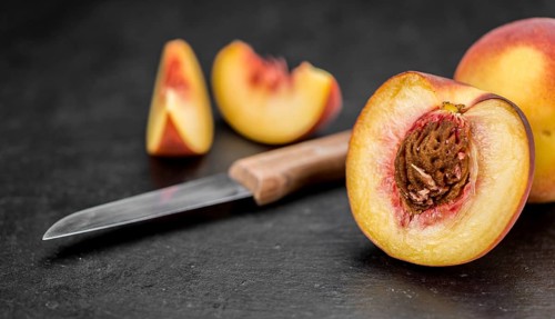 Some Fresh Peaches on a slate slab as detailed close-up shot, selective focus