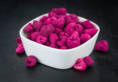 Portion of Dried Raspberries as detailed close up shot on a slate slab, selective focus