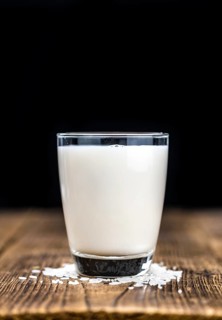 Wooden table with Rice Milk (detailed close-up shot, selective focus)