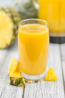 Fresh made Pineapple Juice on an old and rustic wooden table, selective focus, close-up shot