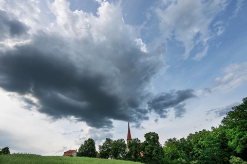 Rain clouds (Nimbostratus), over the church in Beerbach, Middle Franconia, Bavaria, Germany,