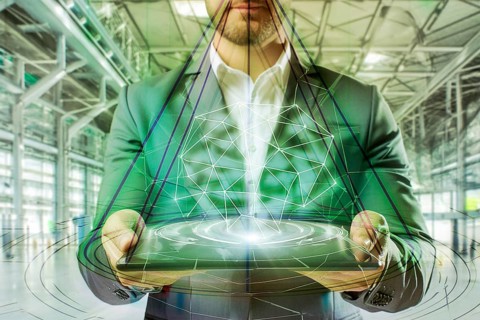 A man in a suit holds a holographic object in a green high-tech factory hall that looks futuristic,