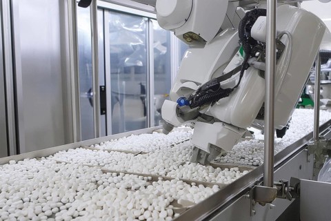 A robotic arm in a production line processes drugs in a modern production facility, AI and