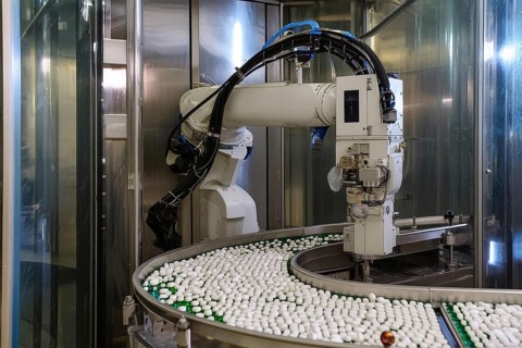 A robotic arm works in a production line for manufacturing medicines in a modern factory, AI and