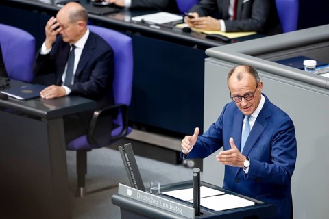 CDU parliamentary group leader Friedrich Merz, right, speaks in the Bundestag, in the background is