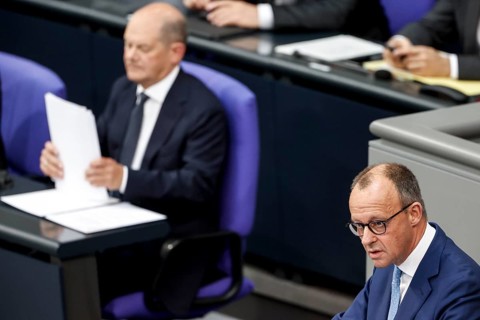 CDU parliamentary group leader Friedrich Merz, right, speaks in the Bundestag, in the background is