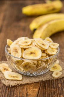 Dried Banana Chips on a vintage background as detailed close-up shot, selective focus