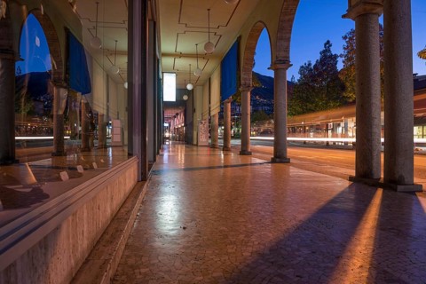 Shopping Street with Shops and Reflection Below Archway in Dusk and Long Exposure in City of