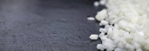 Portion of Chopped white onions as detailed close up shot on a slate slab, selective focus
