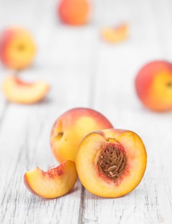 Peaches on an old wooden table as detailed close-up shot, selective focus