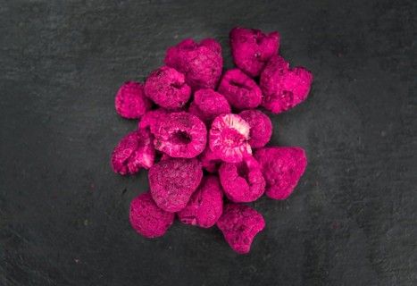 Dried Raspberries on a vintage slate slab as detailed close-up shot, selective focus