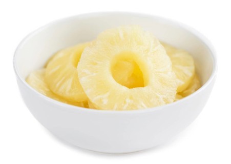 Portion of Preserved Pineapple Rings as detailed close-up shot isolated on white background