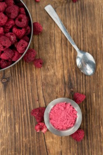 Ground Raspberries on an old wooden table as detailed close-up shot, selective focus
