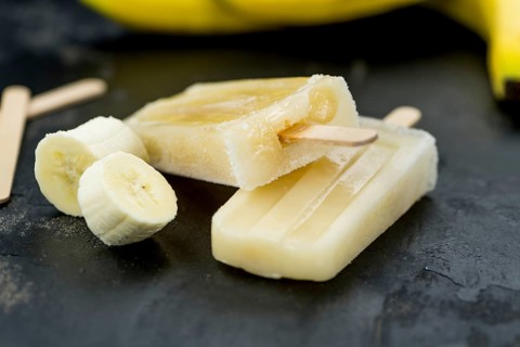Homemade Banana Popsicles on a vintage background (close-up shot, selective focus)