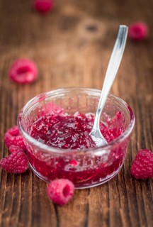 Fresh made Raspberry Jam on an old and rustic wooden table, selective focus, close-up shot
