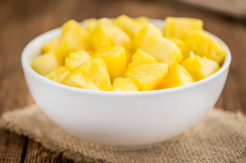 Sliced Pineapple on an old wooden table as detailed close-up shot, selective focus