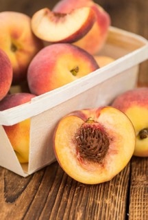 Fresh Peaches as high detailed close-up shot on a vintage wooden table, selective focus
