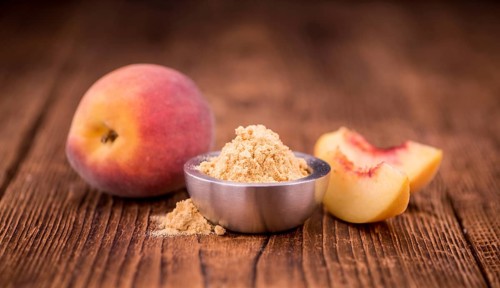 Peach powder on an old wooden table as detailed close-up shot, selective focus
