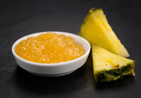 Portion of Pineapple Jam as detailed close up shot on a slate slab, selective focus