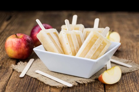 Apple Popsicles on an old wooden table (close-up shot, selective focus)
